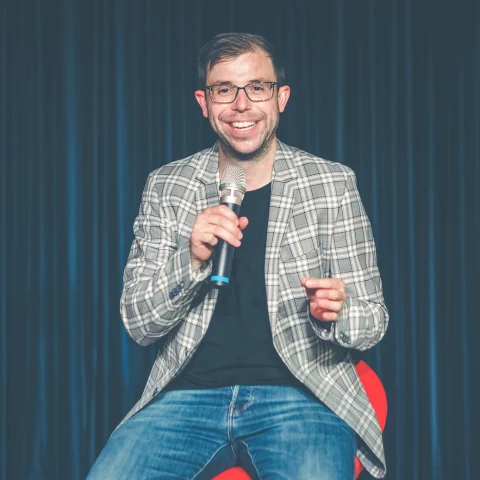 Christian Wirth lacht mit dem Publikum während eines Vortrags